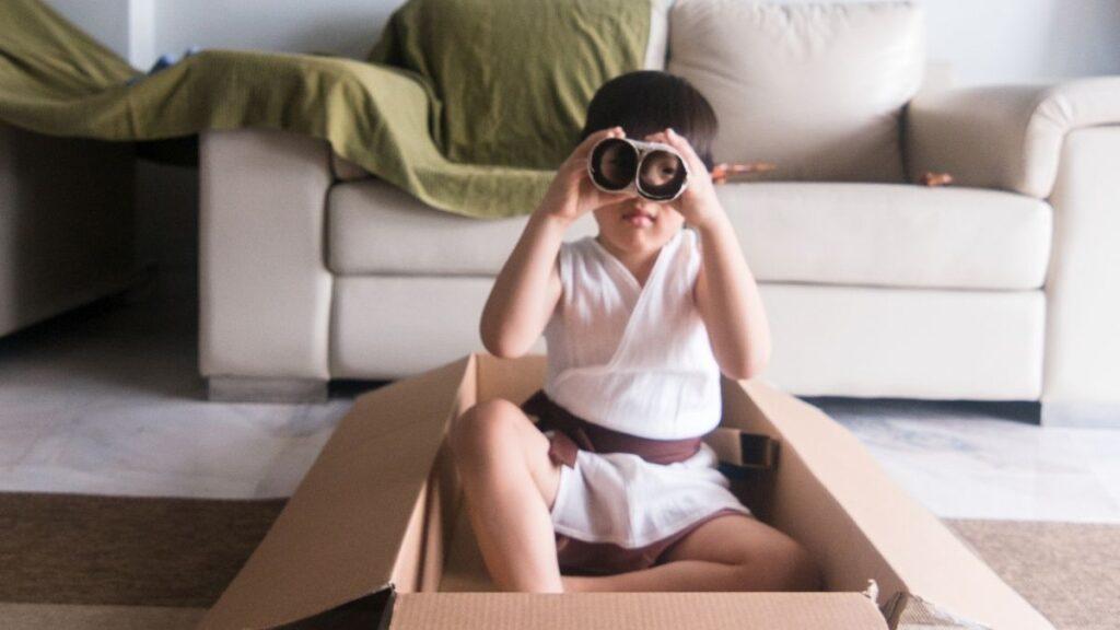 A child playing with his homemade cardboard binoculars
