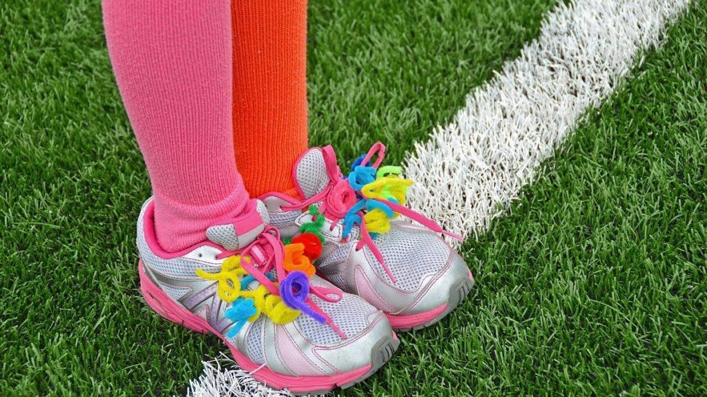A child wearing sneakers with pipe cleaners added to replace shoelaces