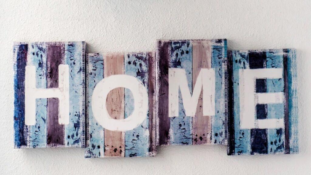 A handmade farm sign with the word Home