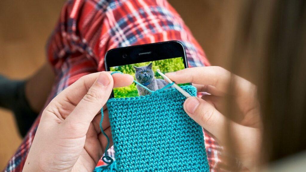 A lady knitting her own phone case