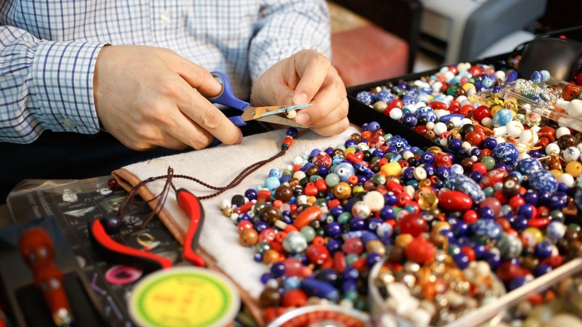 A man crafting handmade beaded jewelry