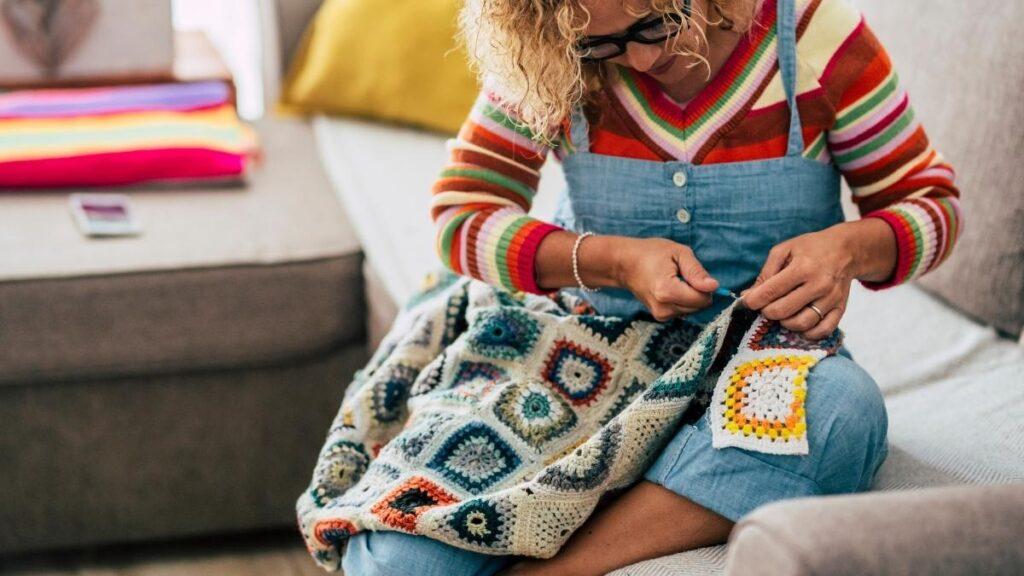 A woman crocheting a patterned blanket