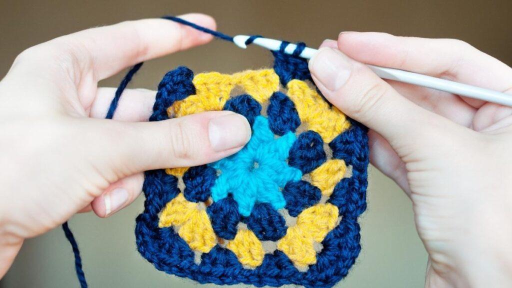 Hands crocheting a granny square