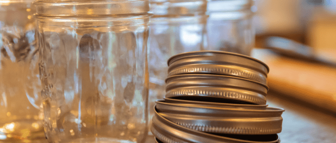 empty canning jars beside stack of lids